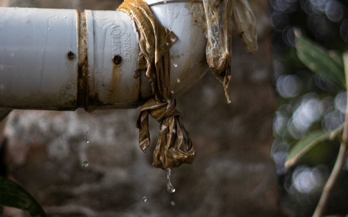Water leaking from a damaged pipe joint inside a wall