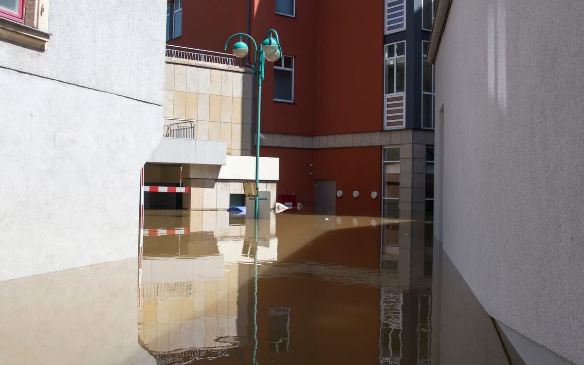 Water flooding a hallway floor during a home plumbing emergency