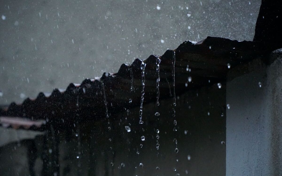 Rain pouring off a roof edge during a Victorian winter storm