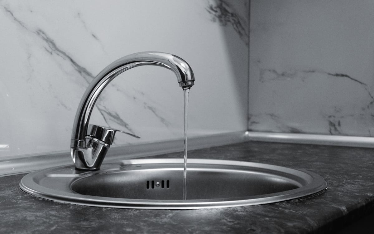 Kitchen mixer tap running into the sink